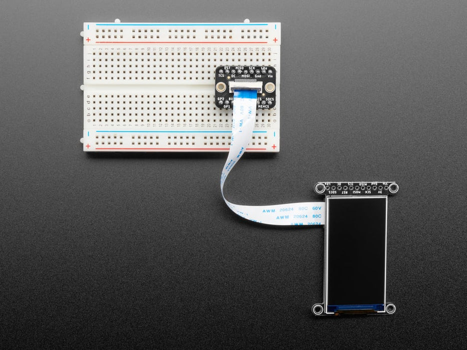 Overhead video of a 1.9" TFT display connected via 18-pin FPC ribbon cable to a square-shaped microcontroller on a breadboard. The TFT plays an animated boot-up demo.