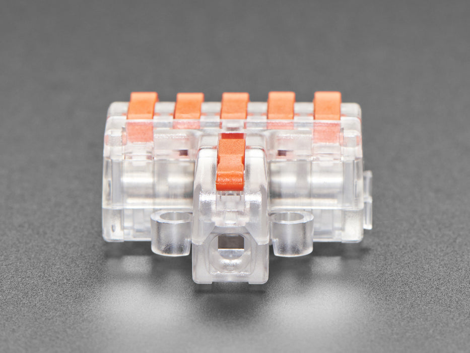 Angled shot of clear 1-to-6 Wiring Block Connector assembled with red wires.