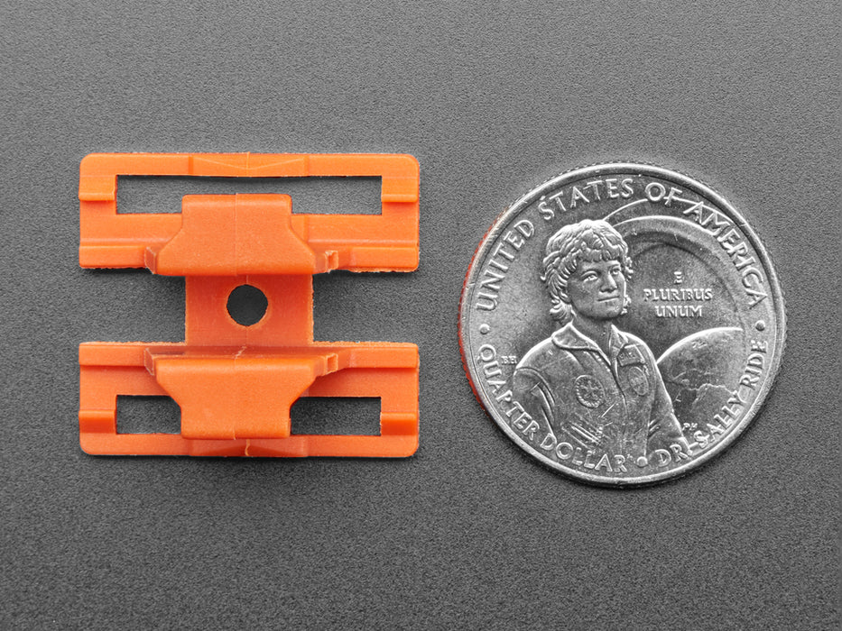 Angled shot of two orange plastic buckles assembled with two different wiring block connectors.