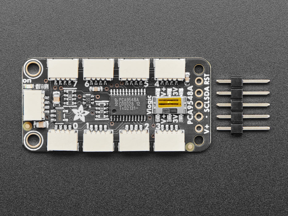 Overhead shot of STEMMA QT breakout board with eight JST-SH ports wired up to four black, rectangular VCNL light sensors. All their indicator LEDs are lit up green.