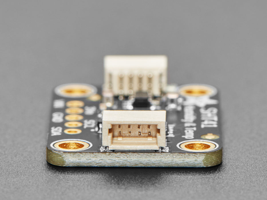 Overhead shot of humidity / temperature sensor breakout connected to an OLD screen, which displays the ambient temperature and humidity.