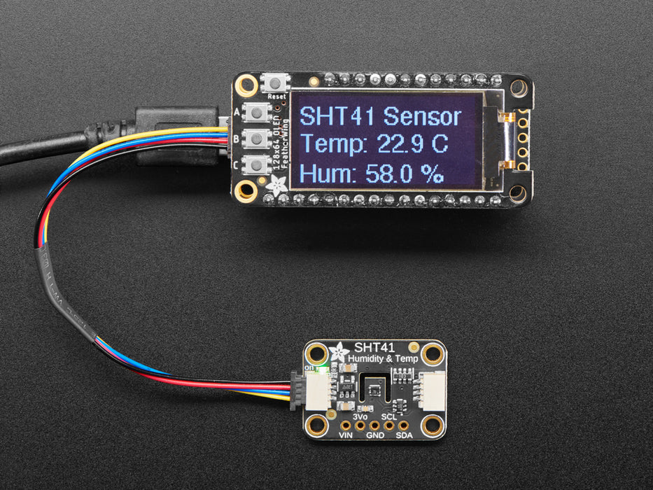 Overhead shot of humidity / temperature sensor breakout connected to an OLD screen, which displays the ambient temperature and humidity.