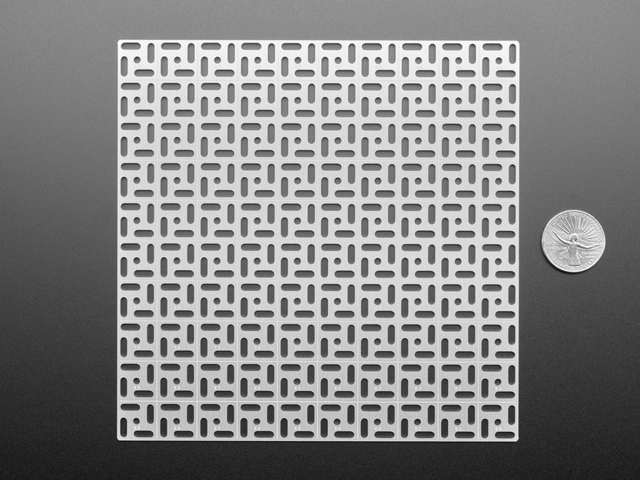 Overhead shot of 10x10 aluminum prototyping grid with a microcontroller and three breakout boards.