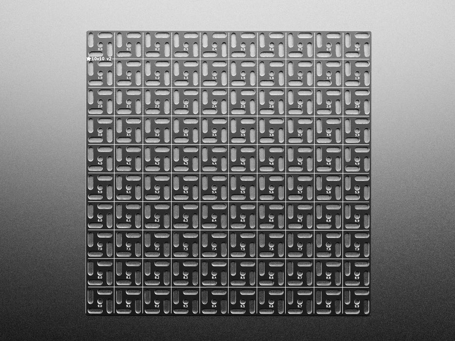 Overhead shot of 10x10 aluminum prototyping grid with a microcontroller and three breakout boards.