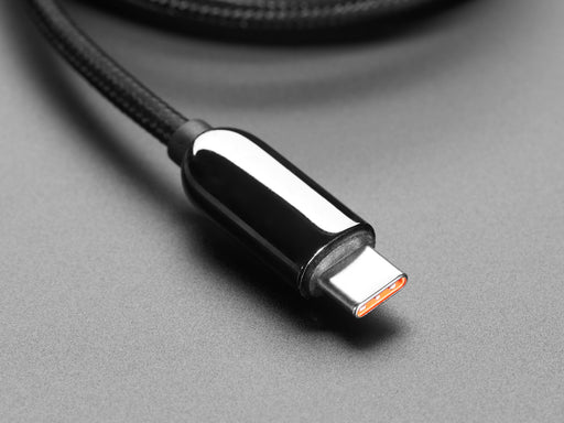 Angled shot of coiled black woven USB A to USB C cable.