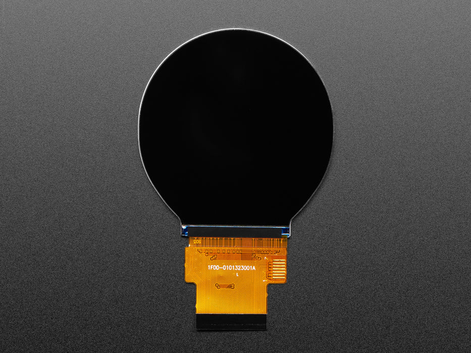 Overhead shot of round TFT display connected to a black, rectangular microcontroller. The TFT displays a rainbow color gradient.