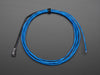 Coil of lit EL wire in blue