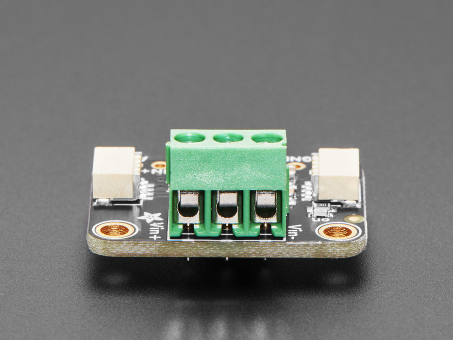 Angled shot of DC current monitor breakout board with green terminal block.