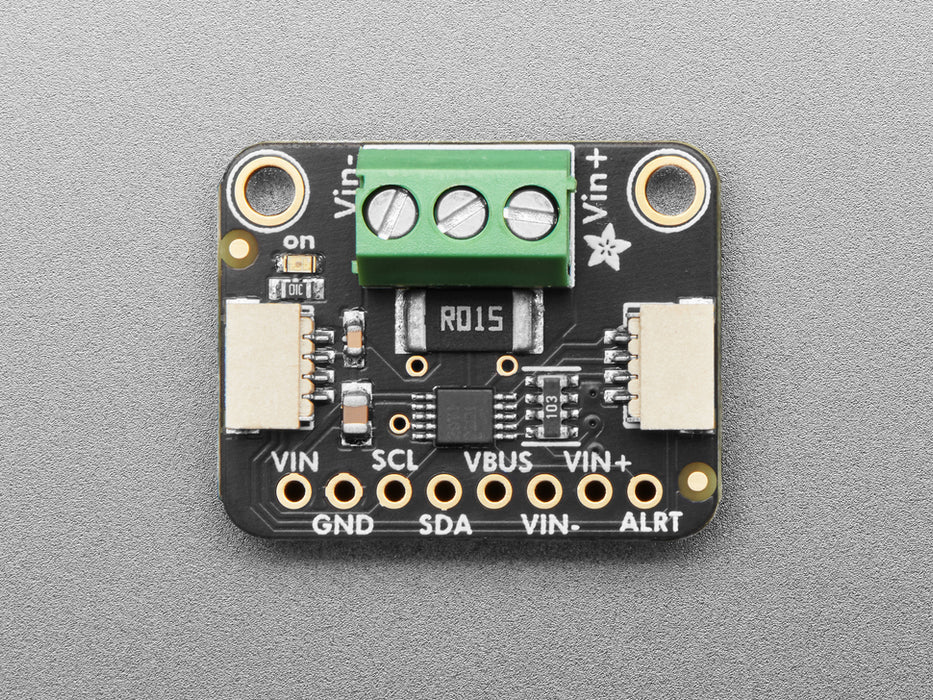 Angled shot of DC current monitor breakout board with green terminal block.