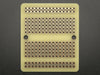 Top view of three fanned out Adafruit Perma-Proto Quarter-sized Breadboard PCBs.