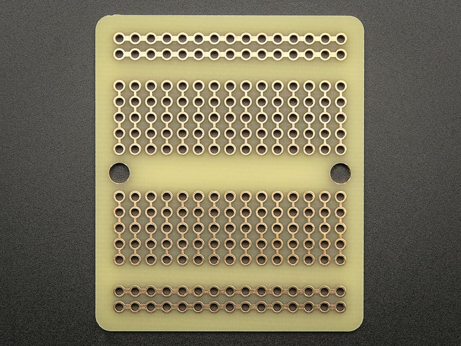 Top view of three fanned out Adafruit Perma-Proto Quarter-sized Breadboard PCBs.