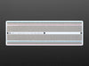 Angled shot of Adafruit Perma-Proto Full-sized Breadboard PCB.