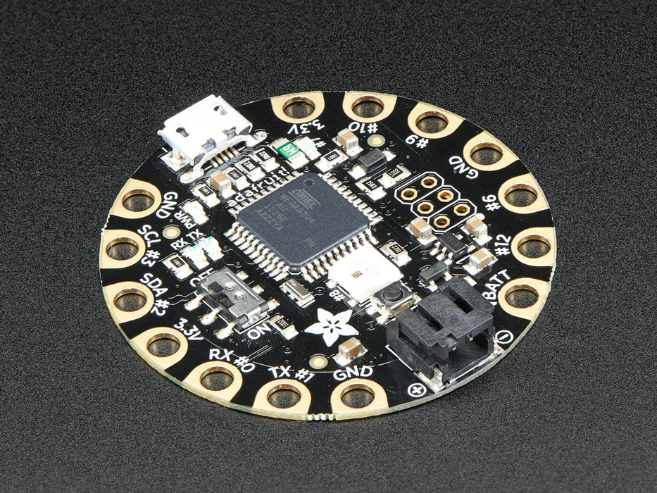 Top down view of a FLORA - Wearable electronic platform: Arduino-compatible connected to 4 alligator clips and a USB powerin the FLORA. 