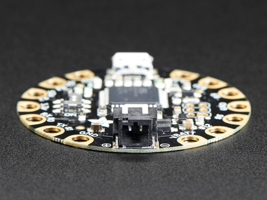 Top down view of a FLORA - Wearable electronic platform: Arduino-compatible connected to 4 alligator clips and a USB powerin the FLORA. 