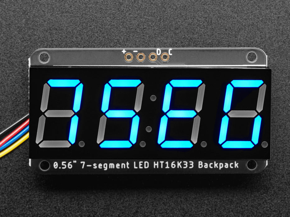 Blue 7-segment clock display soldered to backpack with all segments lit