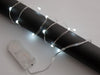 Lit coil of thin flexible wire with embedded LED 'fairy' lights attached to battery holder